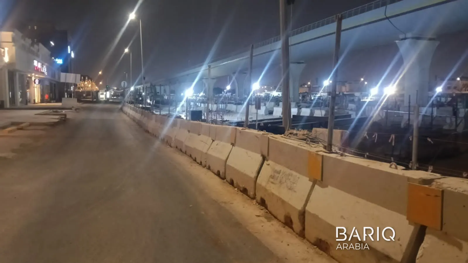 Sports Boulevard site boundary at night with hoarding and barriers