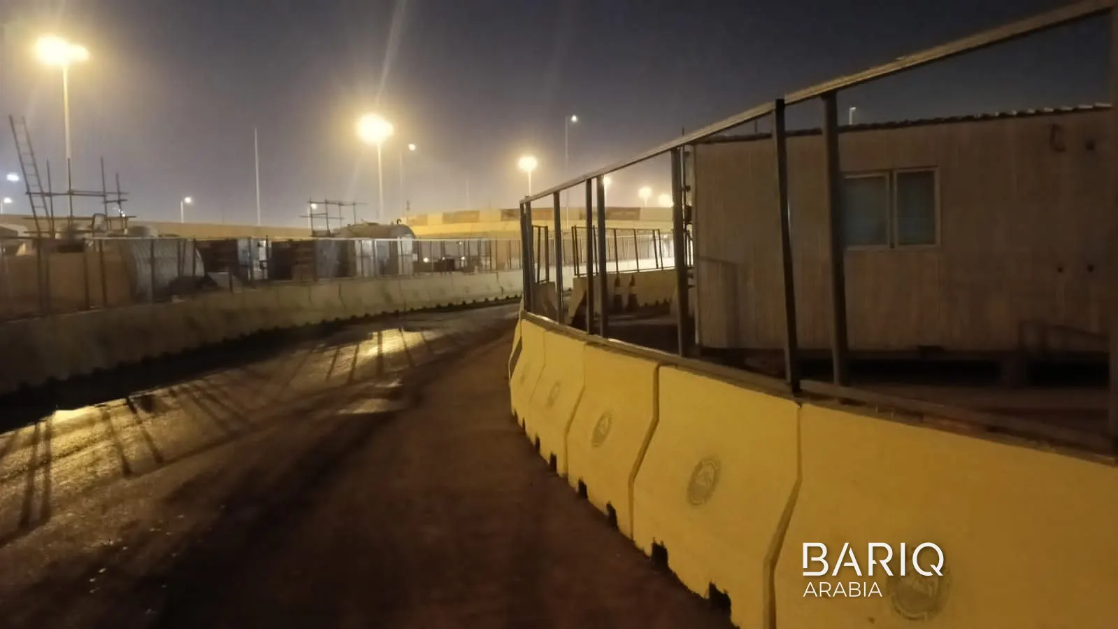 Concrete barriers along the edge of a Diriyah work site at night