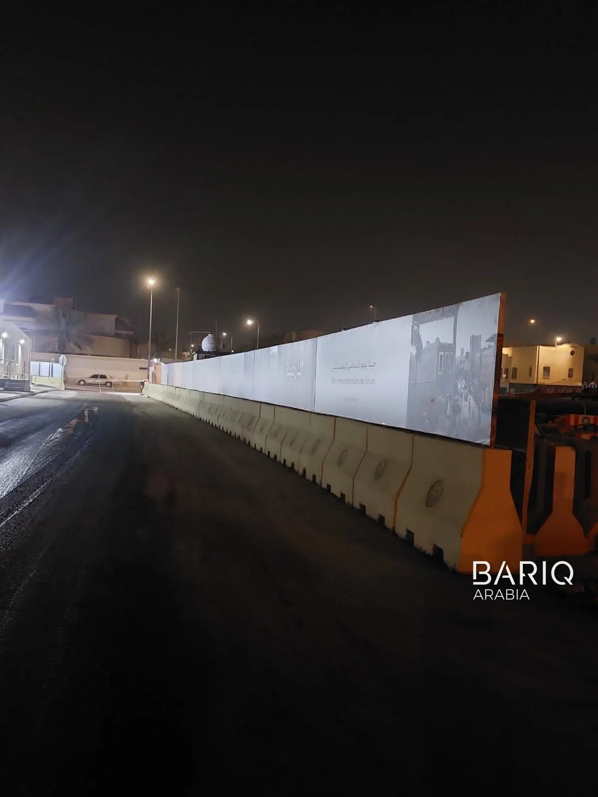 New Jersey barriers under site hoarding on a Diriyah road at night