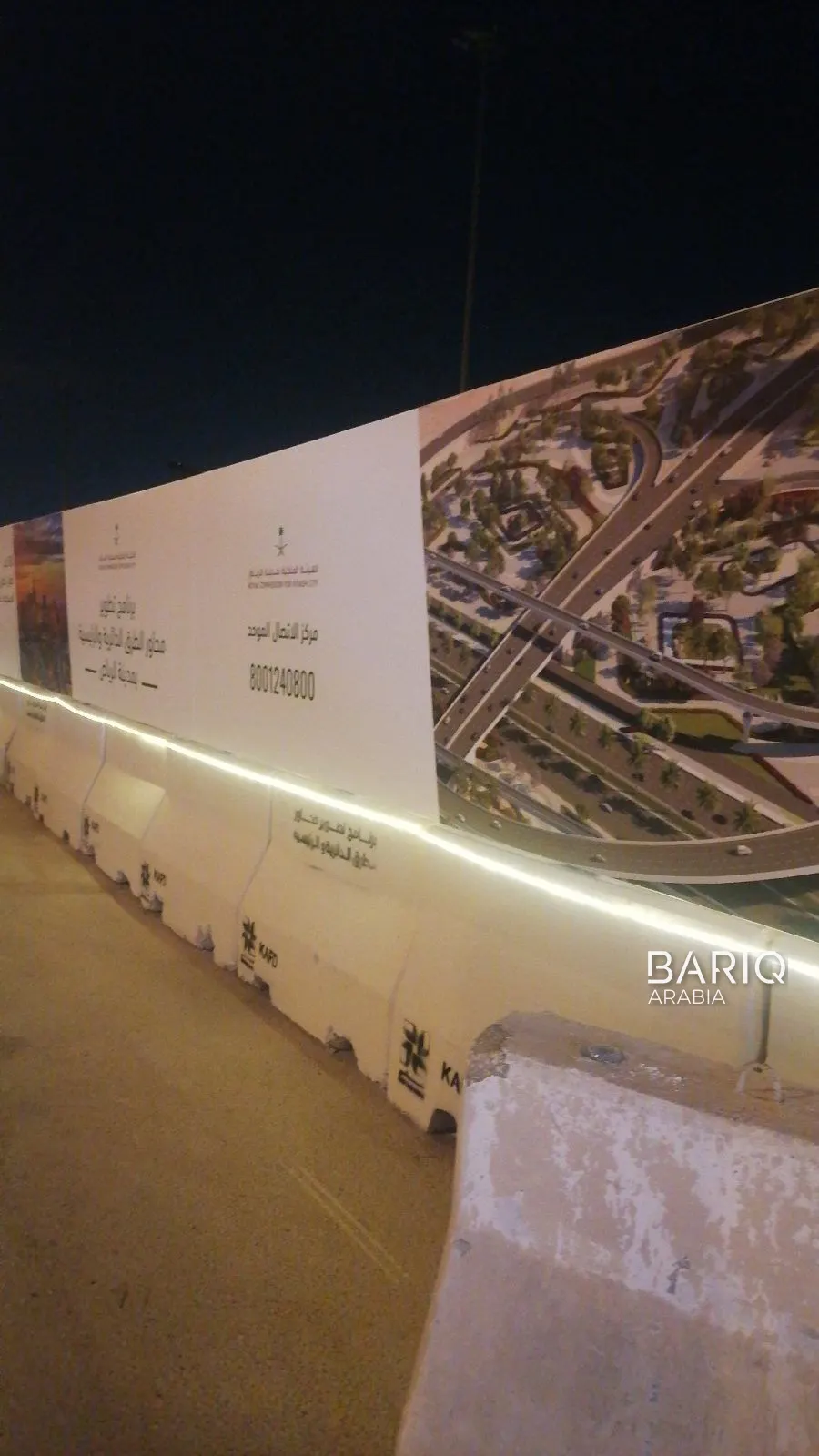 Lit hoarding above concrete barriers on the KAFD road works